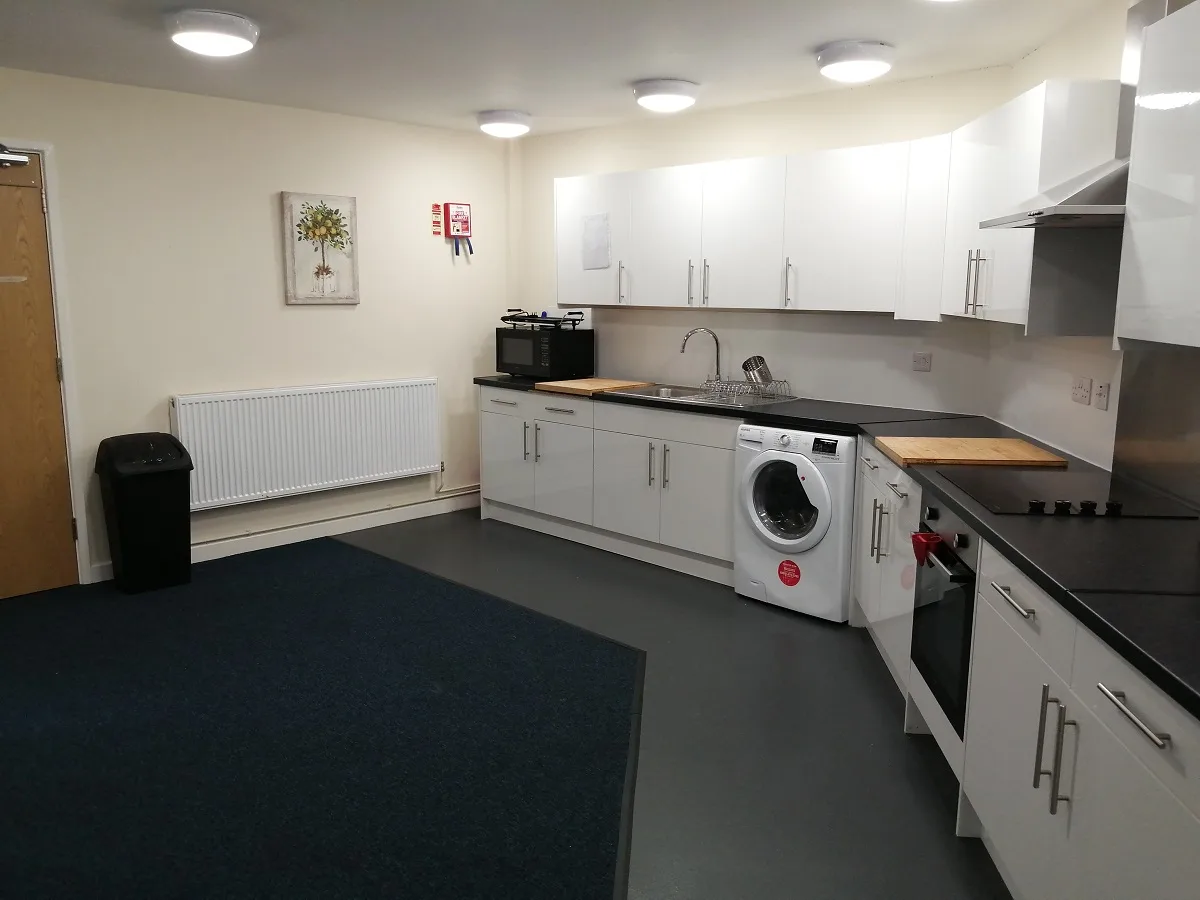 A fitted kitchen with worktop, sink and integrated appliances