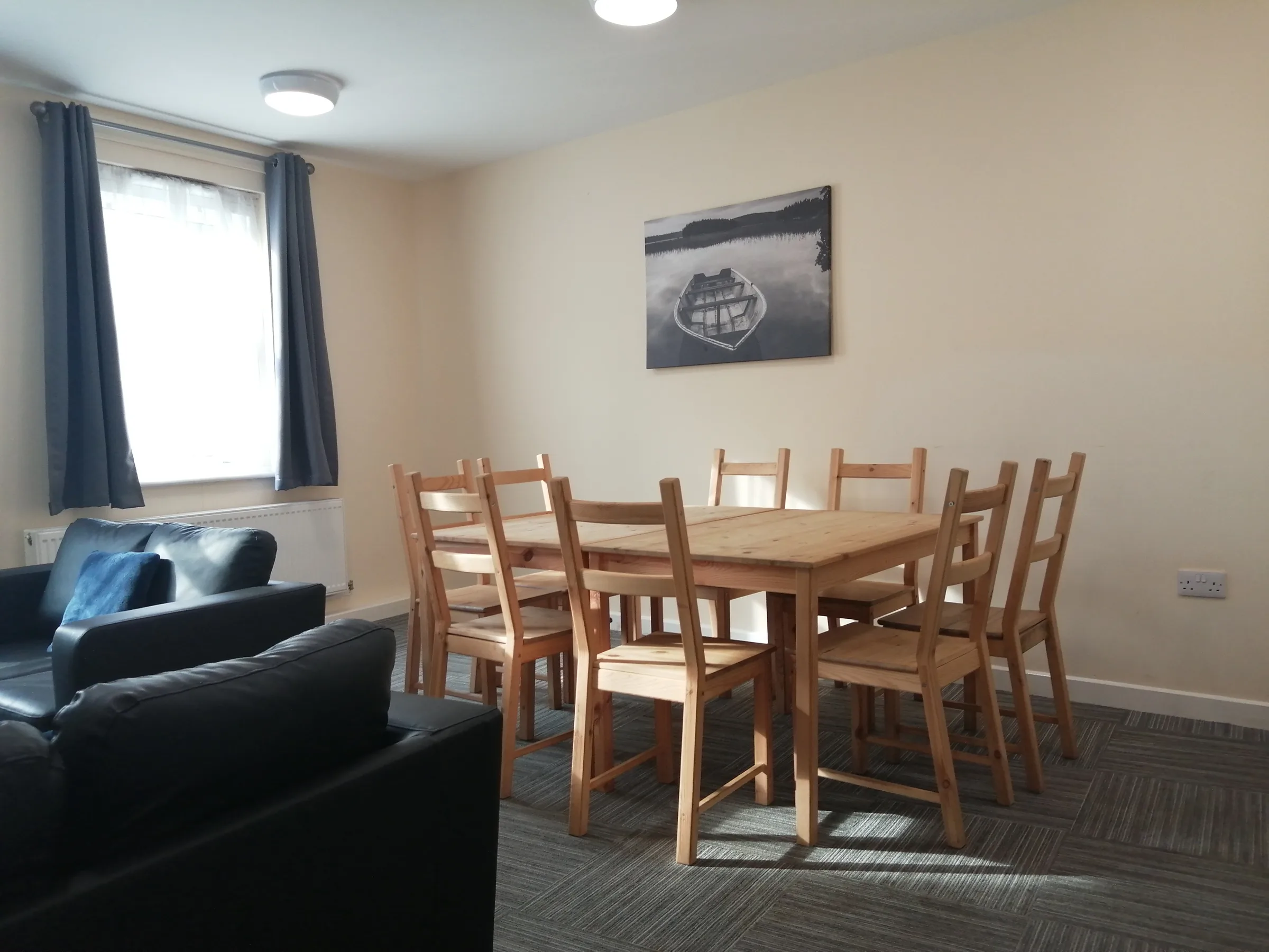 A shared lounge with a dining table for six and a sofa