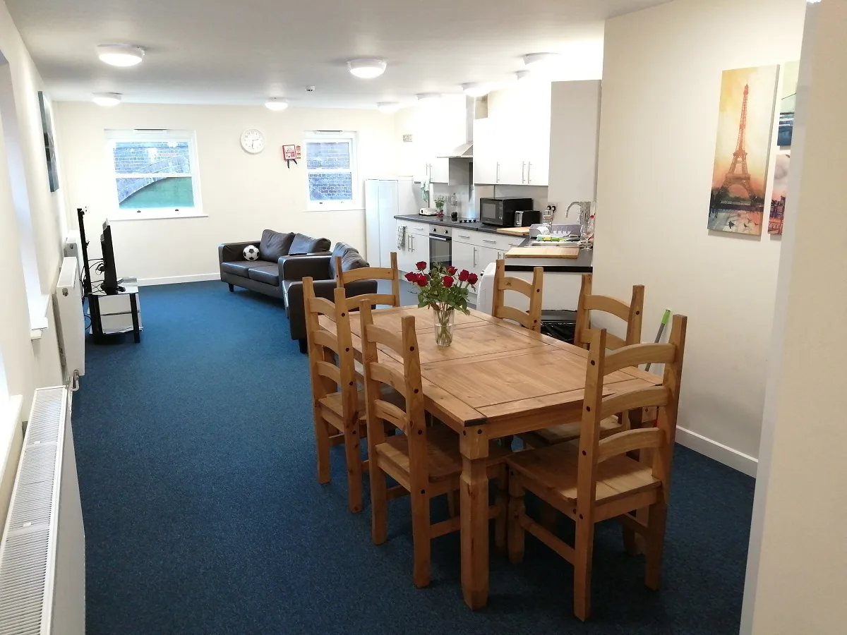 A large open-plan kitchen and lounge with seating and a dining table