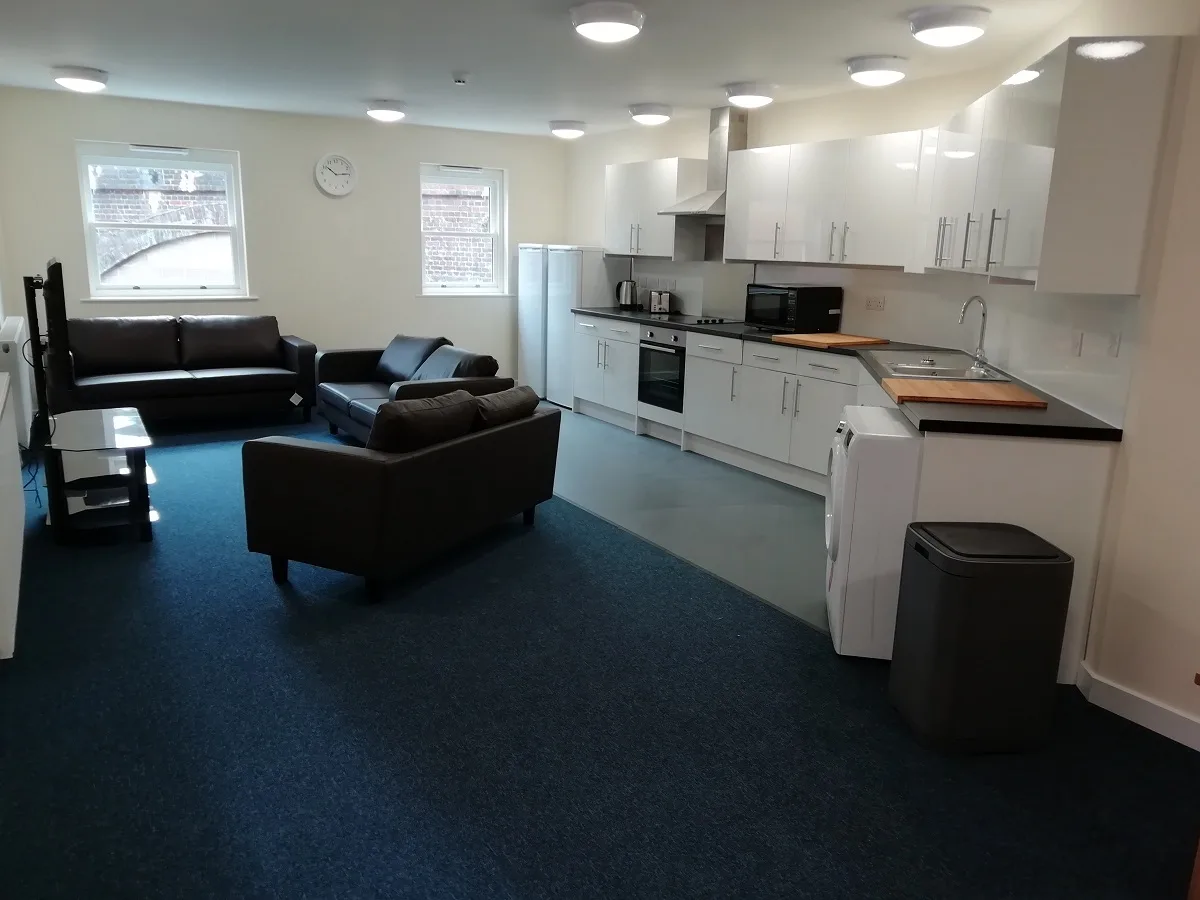 An apartment kitchen and lounge, looking towards the window