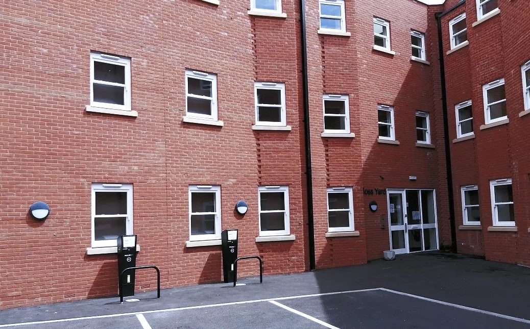 The parking courtyard at Moss Yard, with marked bays and cycle stands