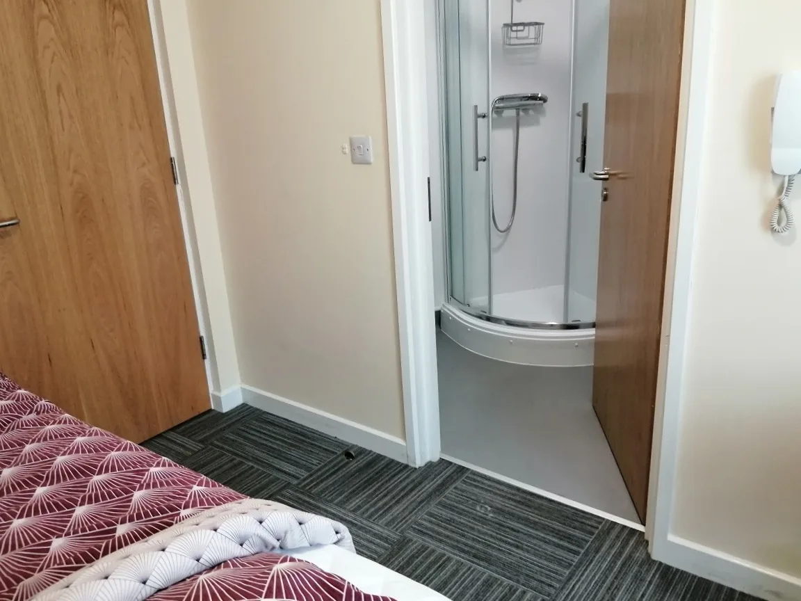 A shower room with a quadrant enclosure, basin and heated rail